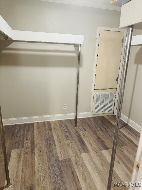 unfurnished bedroom featuring visible vents, baseboards, and wood finished floors