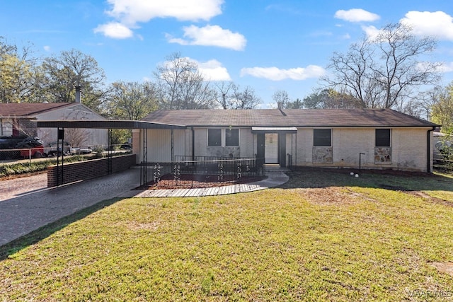 rear view of house with a carport, a yard, and fence