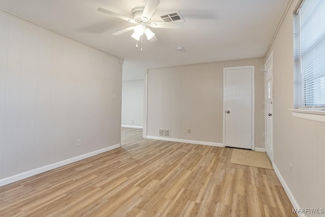 unfurnished room with visible vents, baseboards, light wood-type flooring, and ceiling fan