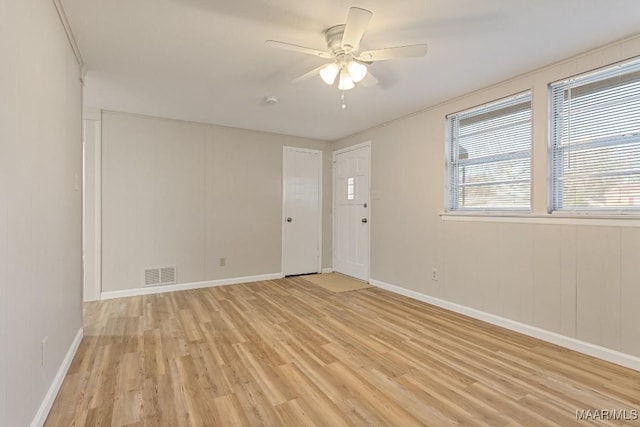 spare room with visible vents, baseboards, light wood-type flooring, and ceiling fan