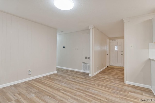 spare room featuring visible vents, baseboards, and light wood-style floors