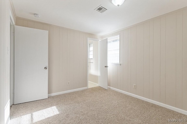 carpeted spare room with visible vents and baseboards