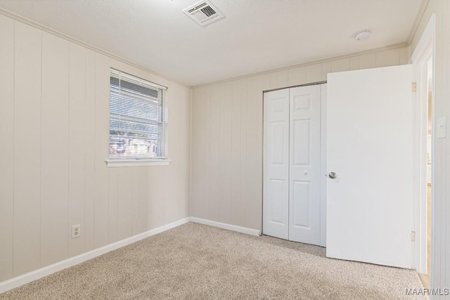 unfurnished bedroom with a closet, visible vents, and carpet floors