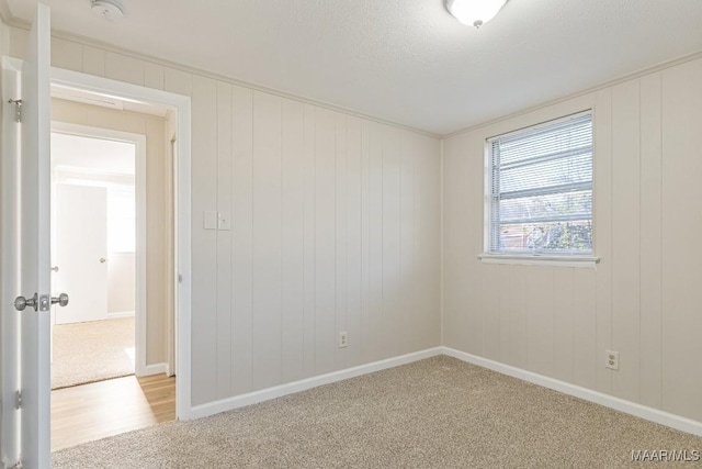 spare room featuring baseboards and carpet flooring