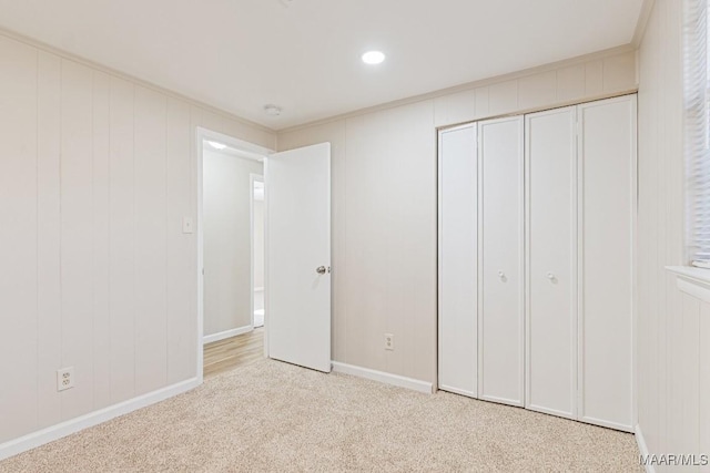 unfurnished bedroom featuring a closet, baseboards, and carpet flooring