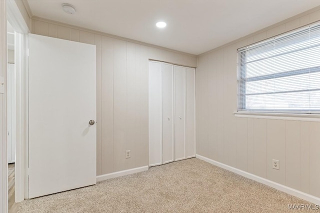 unfurnished bedroom with a closet, carpet flooring, and baseboards