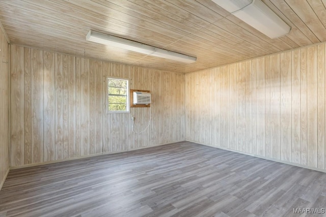 spare room featuring wood ceiling, wood finished floors, and a wall mounted air conditioner