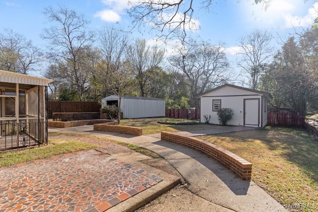 view of yard with an outbuilding, a fenced backyard, and a patio area