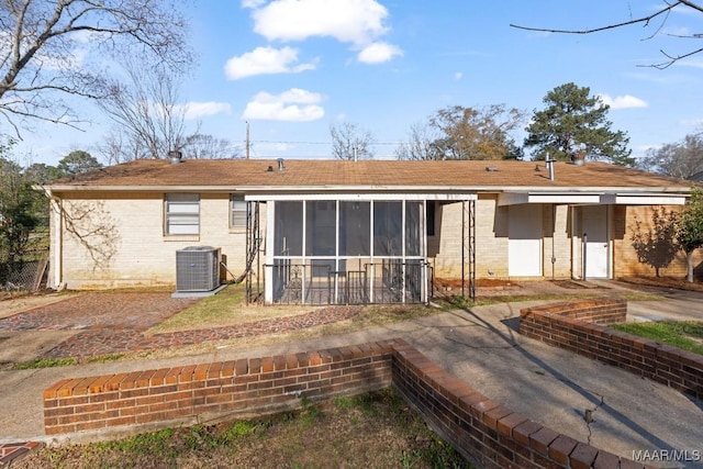 back of property with central air condition unit, brick siding, and a sunroom