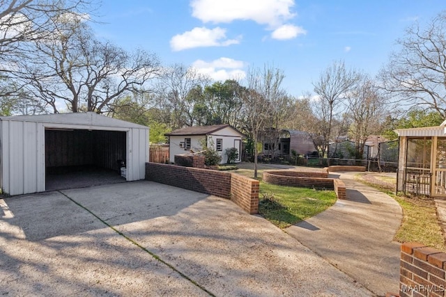 exterior space with an outbuilding, fence, a garage, and driveway