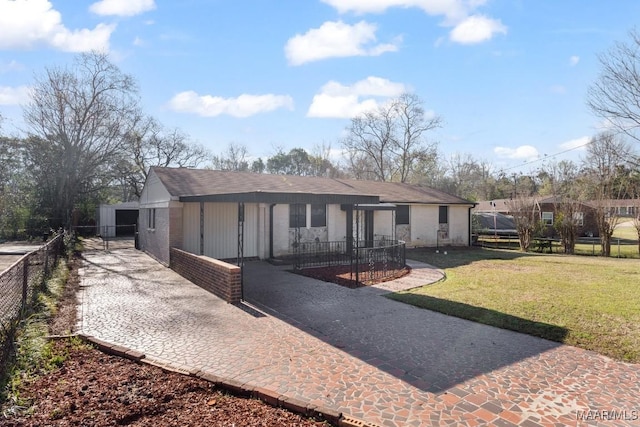 view of front facade with a front lawn, driveway, and fence