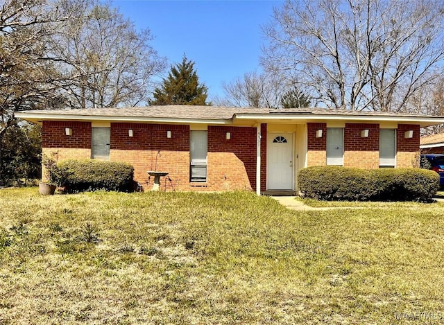 ranch-style home featuring brick siding and a front yard