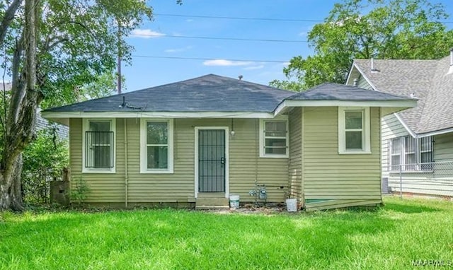 back of property featuring central air condition unit, a lawn, and entry steps