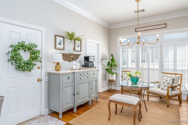 interior space with visible vents, a notable chandelier, ornamental molding, light wood-style floors, and baseboards