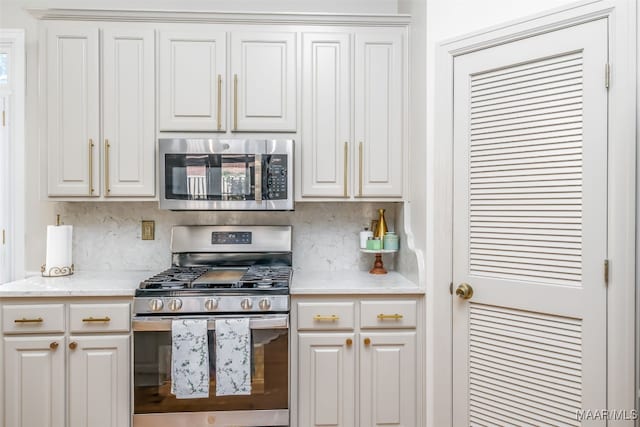 kitchen with stainless steel appliances, tasteful backsplash, and white cabinets