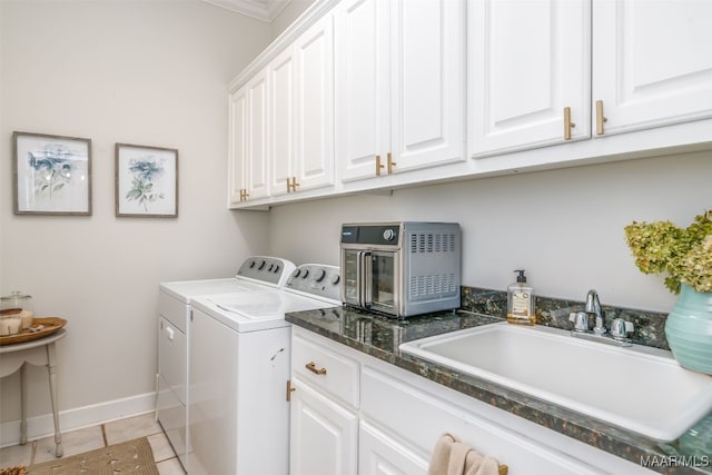 laundry area with a sink, cabinet space, separate washer and dryer, light tile patterned flooring, and baseboards