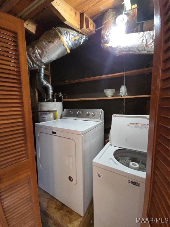 clothes washing area with washer and clothes dryer, laundry area, and water heater