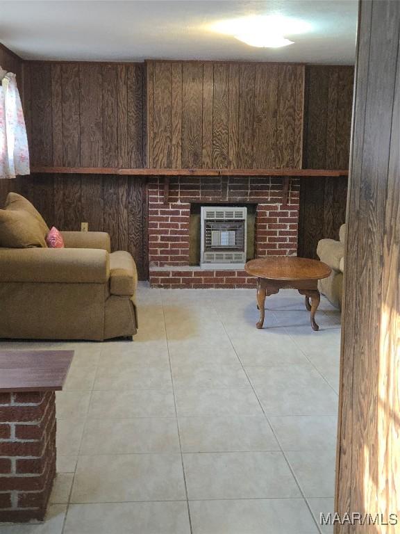 living area featuring heating unit, a fireplace, and wood walls