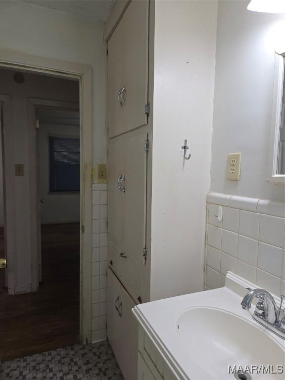 bathroom with tile patterned floors, a wainscoted wall, tile walls, and vanity