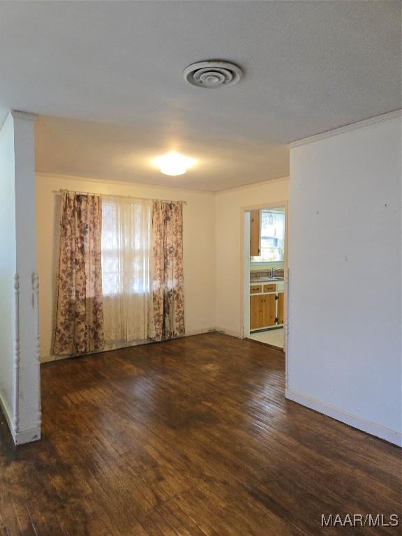 spare room featuring wood finished floors and visible vents