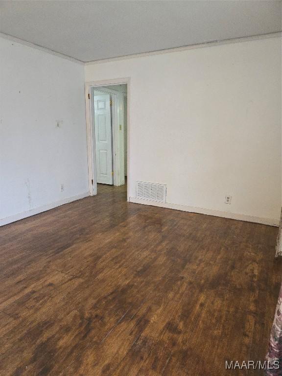 empty room with wood finished floors and visible vents