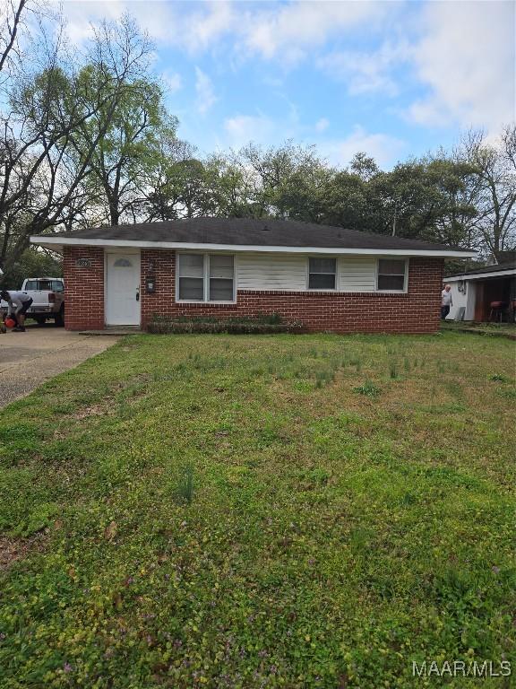 single story home featuring brick siding and a front lawn