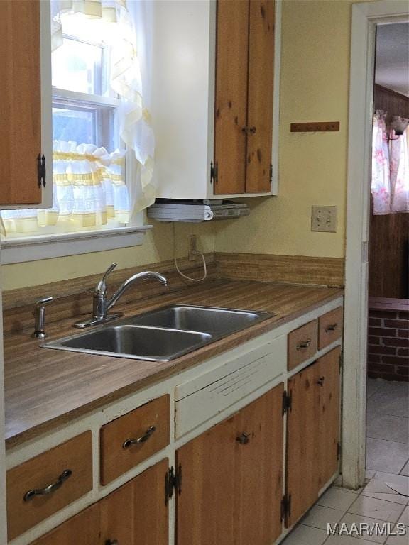 kitchen featuring light tile patterned floors and a sink