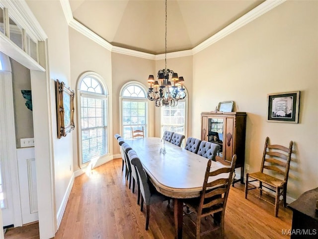 dining space with baseboards, wood finished floors, a chandelier, and ornamental molding