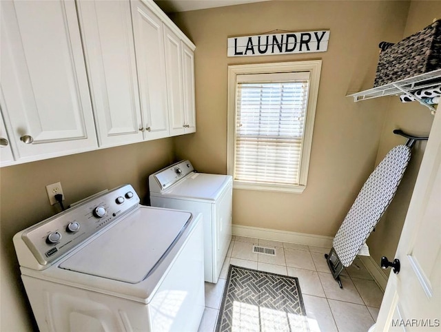 clothes washing area with light tile patterned floors, visible vents, baseboards, cabinet space, and separate washer and dryer