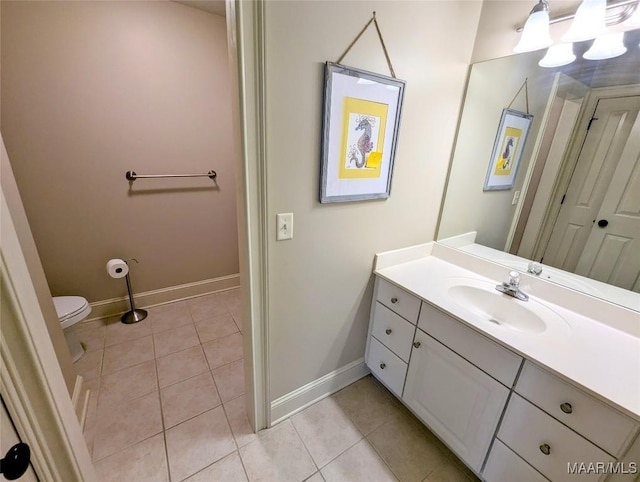 bathroom featuring vanity, baseboards, an inviting chandelier, tile patterned flooring, and toilet