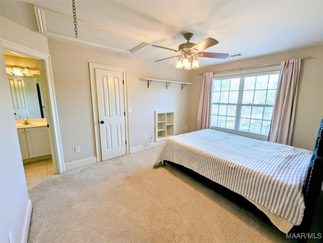 carpeted bedroom featuring visible vents, ensuite bath, baseboards, and a ceiling fan