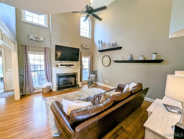 living room with wood finished floors, plenty of natural light, and a ceiling fan