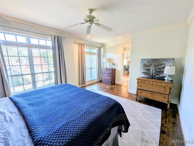 bedroom with baseboards, wood finished floors, ceiling fan, and ornamental molding