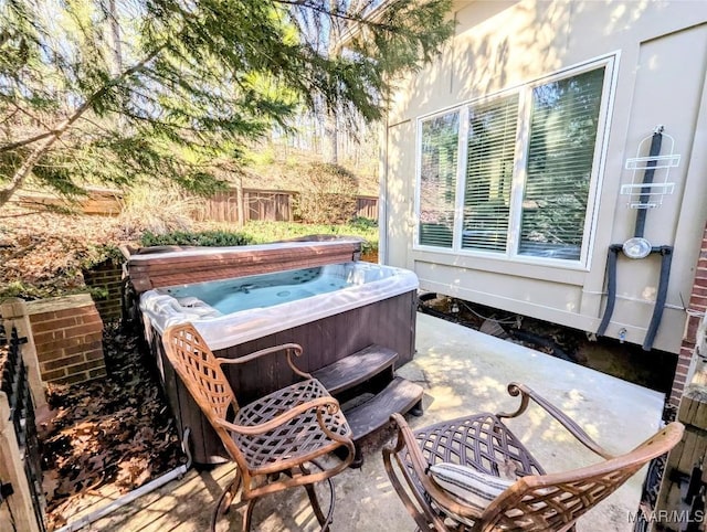 view of patio / terrace with fence and a hot tub