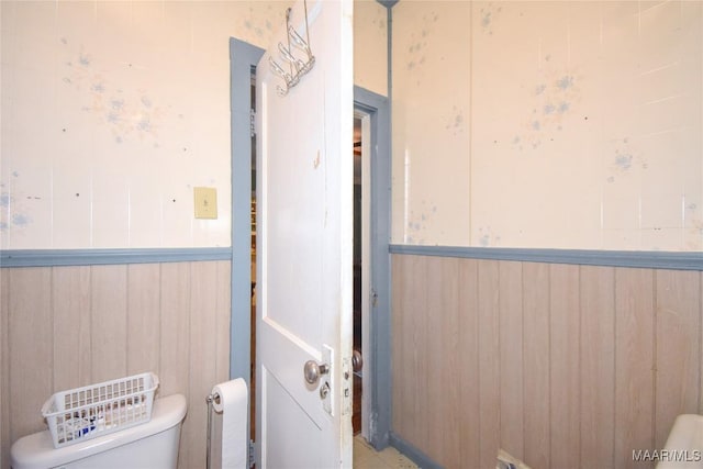 141 S Central Ave, Alexander City, AL 35010 - half bathroom featuring wooden walls, toilet, and wainscoting