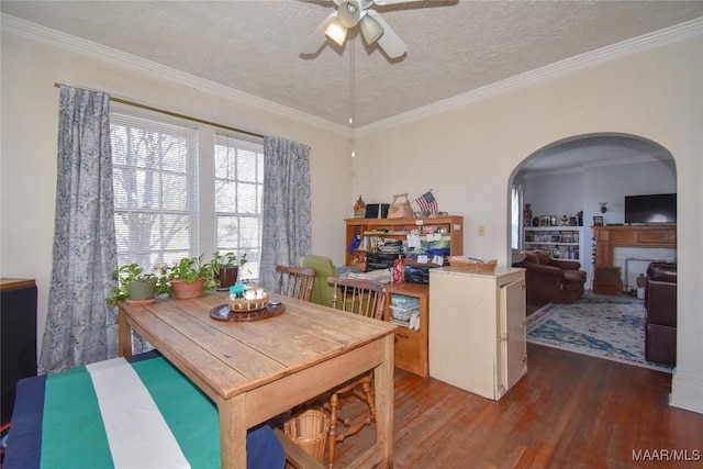 141 S Central Ave, Alexander City, AL 35010 - dining space featuring crown molding, wood finished floors, arched walkways, a textured ceiling, and a ceiling fan