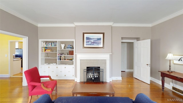 living area featuring ornamental molding, baseboards, and wood finished floors