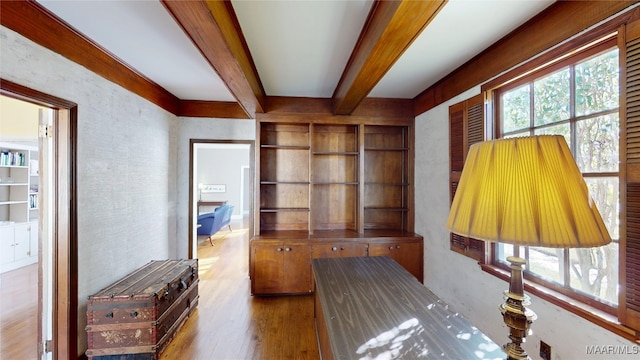 interior space with beam ceiling and wood finished floors