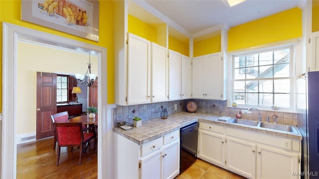 kitchen featuring decorative backsplash, visible vents, white cabinetry, and a sink