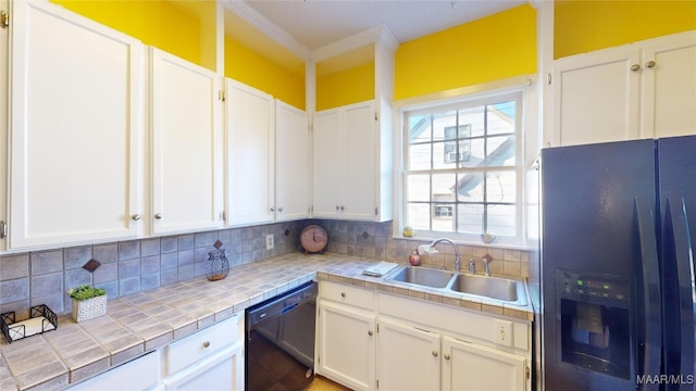 kitchen with black appliances, a sink, backsplash, white cabinetry, and tile countertops