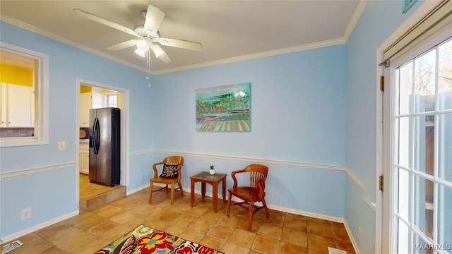 sitting room with visible vents, baseboards, ornamental molding, and a ceiling fan