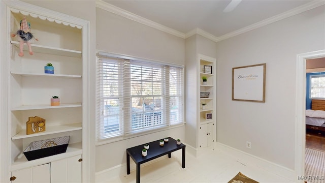 sitting room featuring built in shelves, crown molding, and baseboards