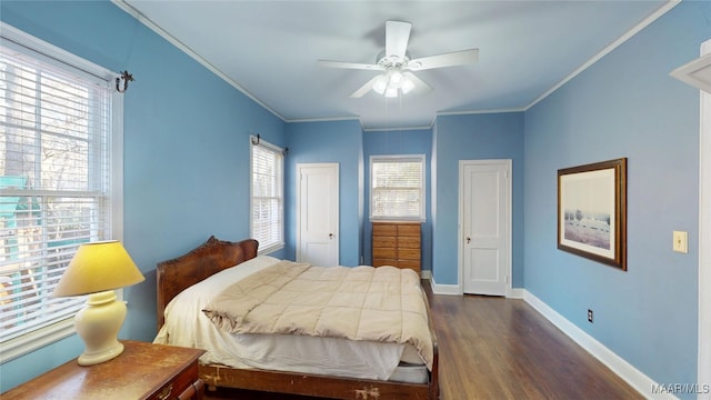 bedroom with crown molding, a ceiling fan, dark wood-type flooring, and baseboards