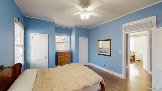 bedroom featuring dark wood-style floors, baseboards, ornamental molding, and a ceiling fan