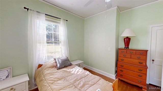 bedroom featuring ceiling fan, crown molding, baseboards, and wood finished floors