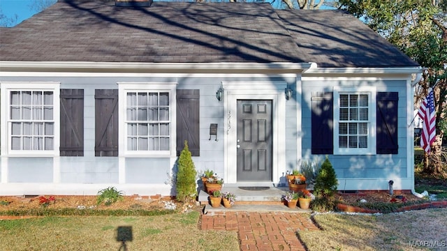 doorway to property featuring crawl space and roof with shingles