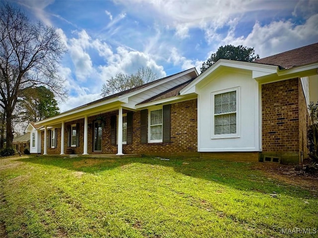 view of front of home with brick siding and a front lawn