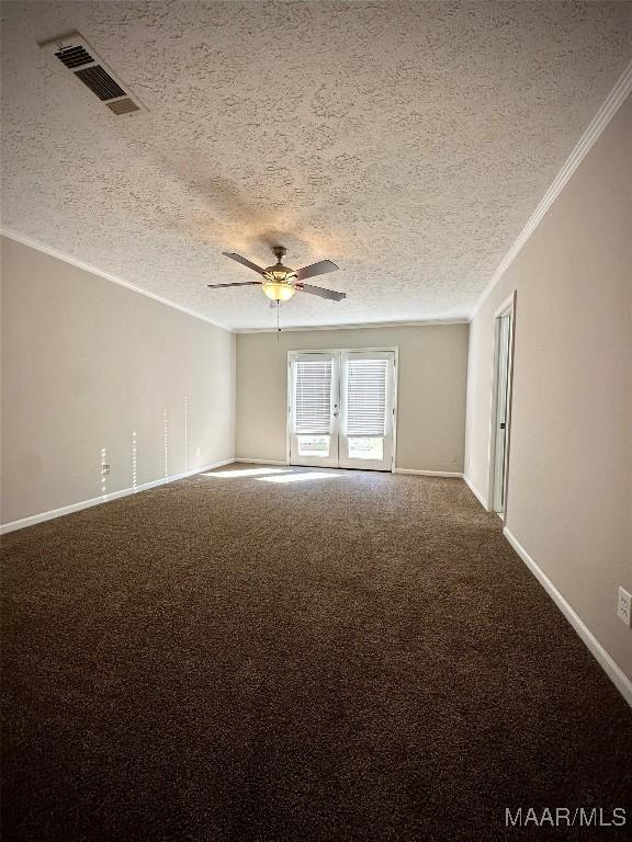 carpeted spare room featuring visible vents, baseboards, a ceiling fan, and ornamental molding