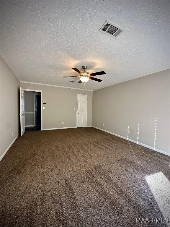 carpeted spare room featuring visible vents, baseboards, a textured ceiling, and ceiling fan