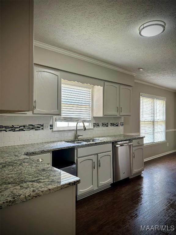 kitchen featuring a sink, decorative backsplash, stainless steel dishwasher, and crown molding